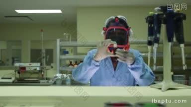 医疗设施和制药实验室，女科学家戴着<strong>防护</strong>口罩，看着摄像机工作